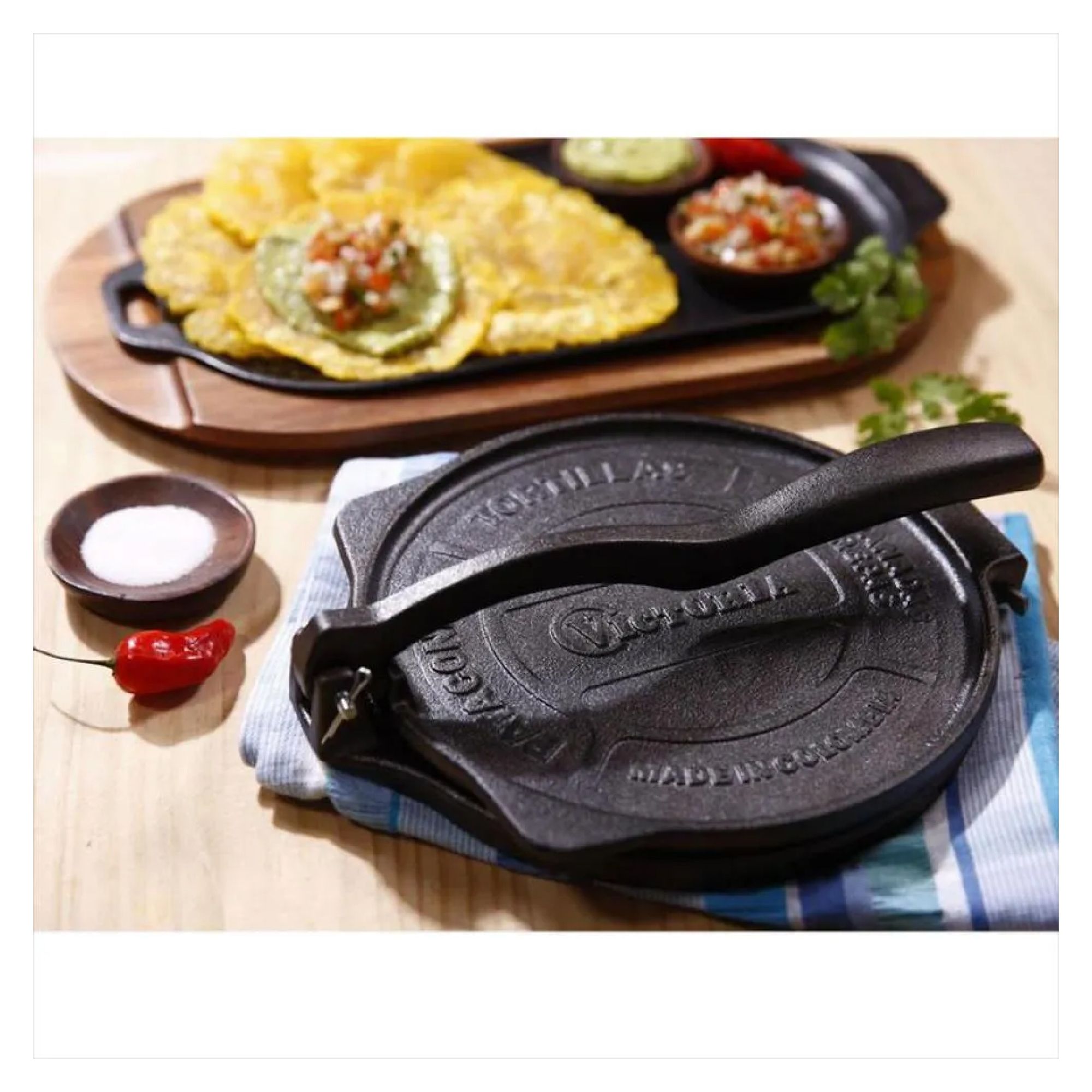 Pataconera de hierro fundido de la marca Victoria en una mesa de madera y plátano